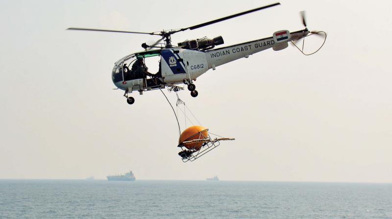 An Indian Coast Guard helicopter transports an Oil Spill Disperser (OSD) from the coastguard ship, Varad during a scout for oil spills over the waters of the Bay of Bengal, off the coast of Chennai.(Photo: E.K. Sanjay)