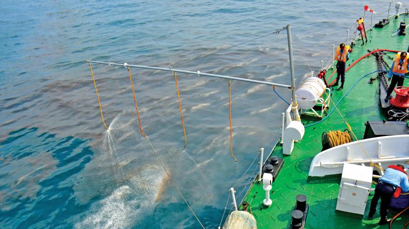 Indian Coast Guard cadets sprinkle Oil Spill Dispersant (OSD) onto to an oily tide off Chennai coast. The chemical increases the density of the particle, thus taking the sludge to the ocean bed. (Photo: DC)