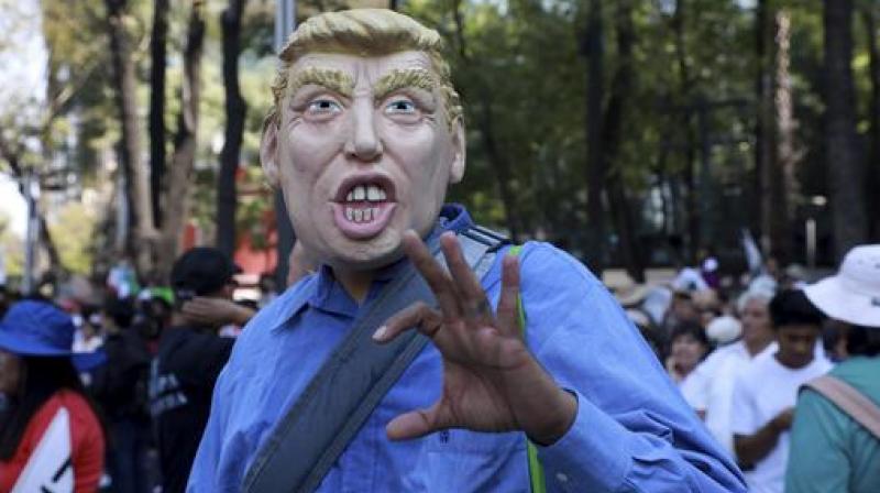 A man wears a mask depicting U.S. President Donald Trump during a march demanding respect for Mexico and its migrants, in the face of perceived hostility from the Trump administration, in Mexico City. (Photo: AP)