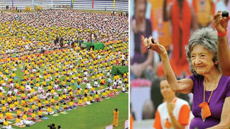 From Left, volunteers perform Yoga asanas and 98-year-old yoga practitioner, Tao Por Tin Lynch from United States  at Sri Kanteerava Stadium in Bengaluru on the occasion of 3rd edition of International Yoga Day on Wednesday  Shashidhar B