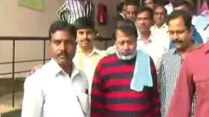 A file photo of film producer Anand Appugol (centre) being taken to court from jail. (Photo: DC)