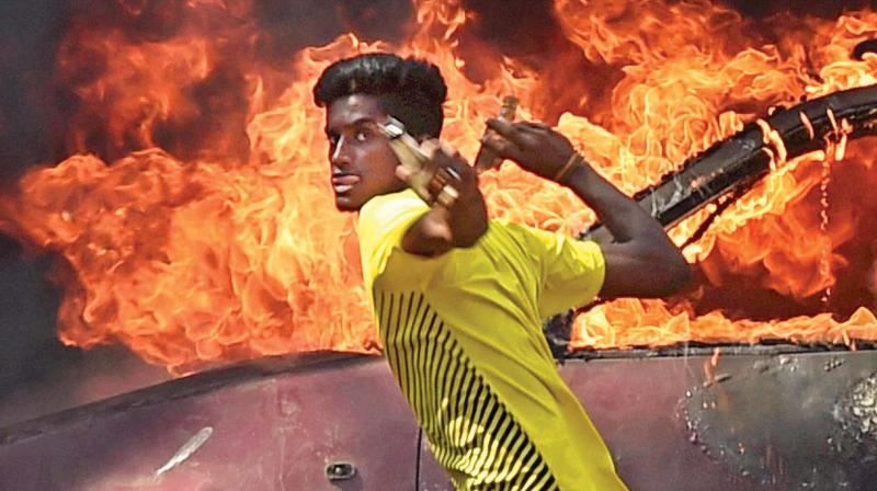 A pro-jallikattu protester throwing bottles at police personnel during a clash near Marina beach in Chennai on Monday (Photo: AP)