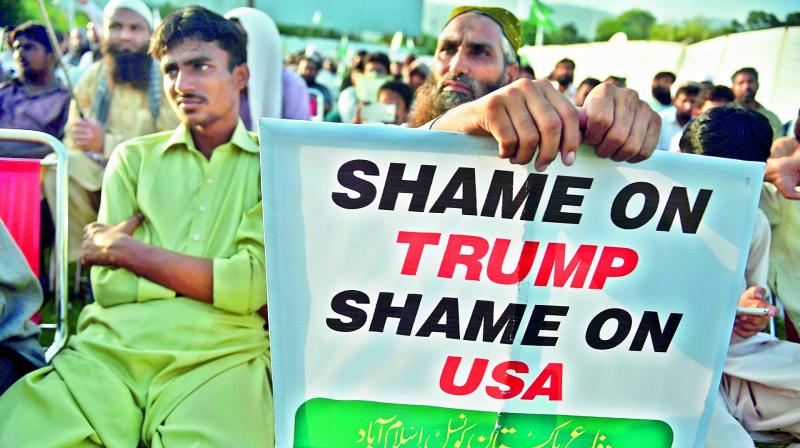 Supporters of the Pakistan Defense Council, an alliance of hardline Islamist religious leaders and politicians, gather during an anti-US protest in Islamabad on Sunday. Police used tear gas and batons to disperse protesters in Karachi. 	 AFP