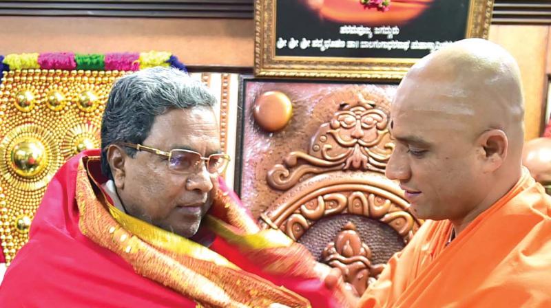 Chief Minister Siddaramaiah with Sri Nirmalanandanatha Swami of Adichunchanagiri Mutt at Vijayanagar in Bengaluru on Sunday 	 KPN