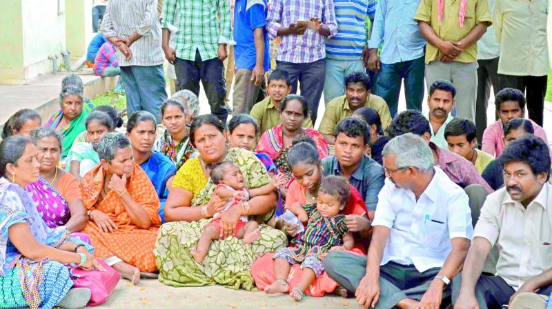 Municipal employees family members and relatives and CPM leader Ch. Babu Rao stage a dharna at the new government hospital demanding compensation in Vijayawada on Thursday. (Photo: DC)