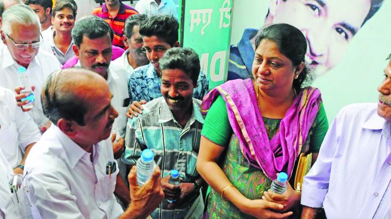 DCC president P.A. Madhavan distributes drinking water bottles to customers of banks standing in the queue in Thrissur on Monday. (Photo: ANUP K VENU)