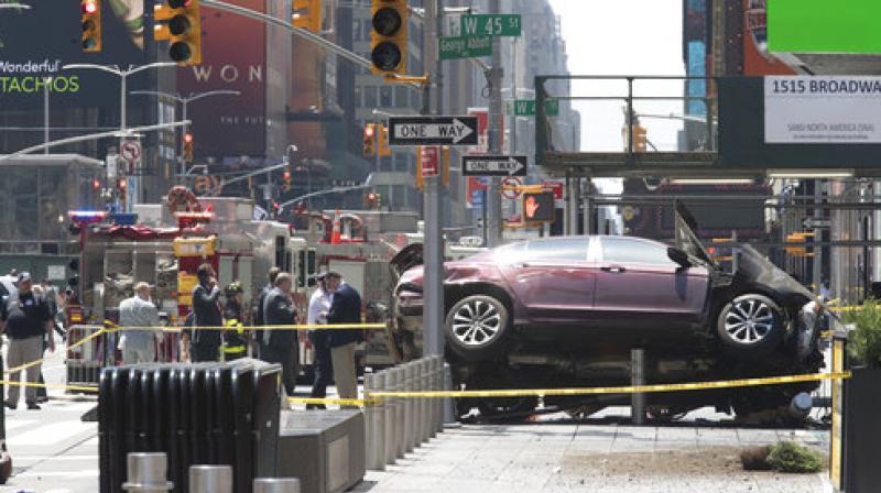 A car rests on a security barrier in New Yorks Times Square after driving through a crowd of pedestrians, injuring at least a dozen people. (Photo: AP)