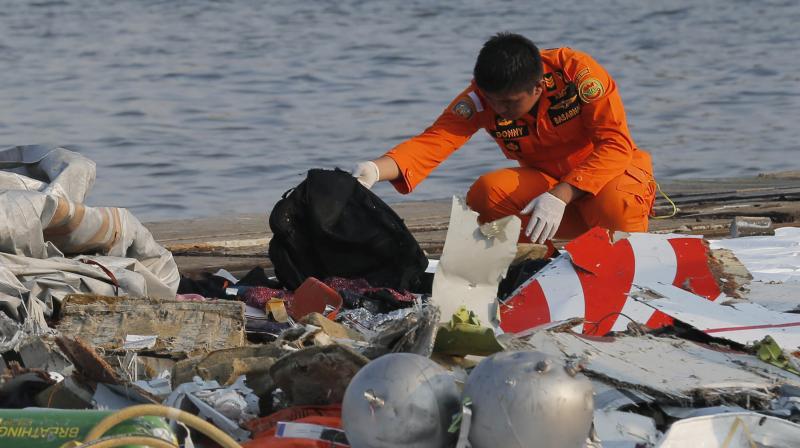 A member of Indonesian Search and Rescue Agency (BASARNAS) inspects debris believed to be from Lion Air passenger jet that crashed off Java Island at Tanjung Priok Port in Jakarta, Indonesia Monday, Oct. 29, 2018. (Photo: AP)