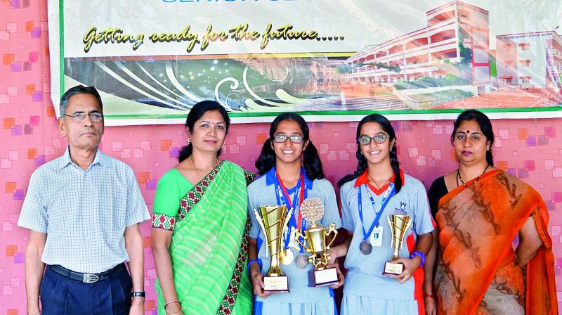 Sasya (second from left) and Laasya pose with their trophies from the CBSE national table tennis championship along with Secunderabad Public School principal Sujatha (left) and vice-principal Sri Vijaya.
