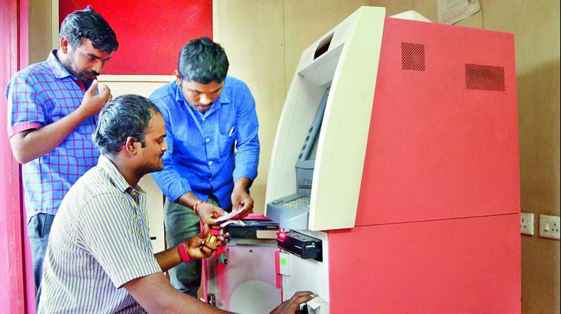 Technical teams re-calibrating ATMs with new currency in Nellore city on Friday.