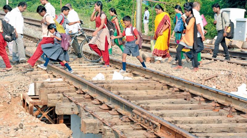 Students cross railway tracks at the closed level crossing 4 at Korattur. (Photo: DC)