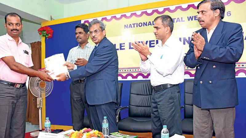 Chief postmaster general Dr Charles Lobo gives away a best performance award on Friday. Postmaster general (mails & BD) J.T. Venkateswarlu is also seen.(Photo: DC)