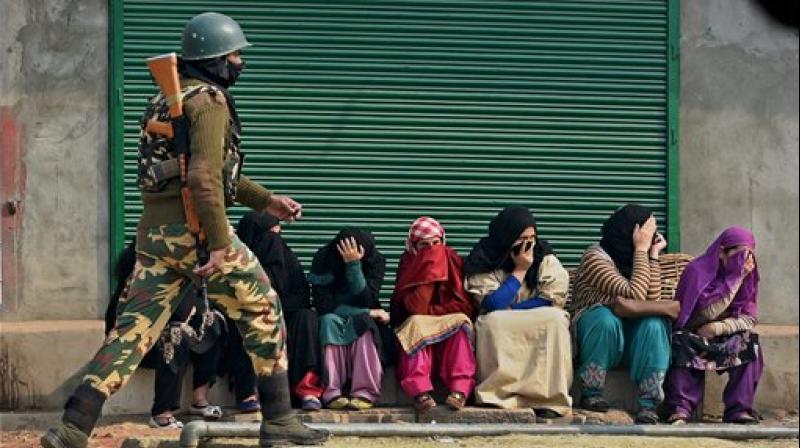 Parents wating outside an examination centre for their wards in Srinagar on Monday. (Photo: PTI)