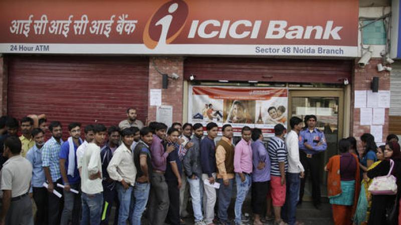 People stand in a queue to deposit and exchange discontinued currency notes. (Photo: PTI)