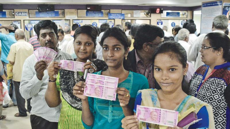 Youngsters proudly display the new notes of Rs 2,000 at IOB Purasaiwakkam on Friday. (Photo: DC)