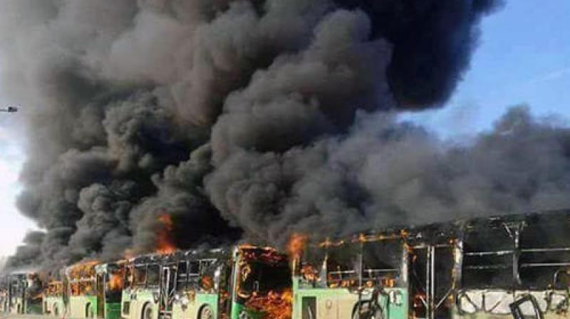 In this photo released by the Syrian official news agency SANA, smoke rises in green government buses, in Idlib province, Syria. (Photo: AP)