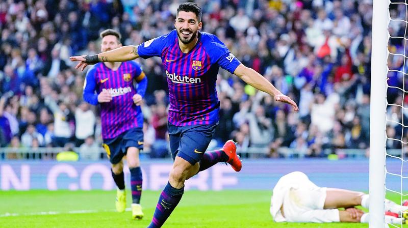 Barcelona forward Luis Suarez celebrates after Real defender Raphael Varane scores an own goal during their Copa del Rey semifinal second leg at the Bernabeu stadium in Madrid on Wednesday. Barcelona won 3-0. (Photo: AP)