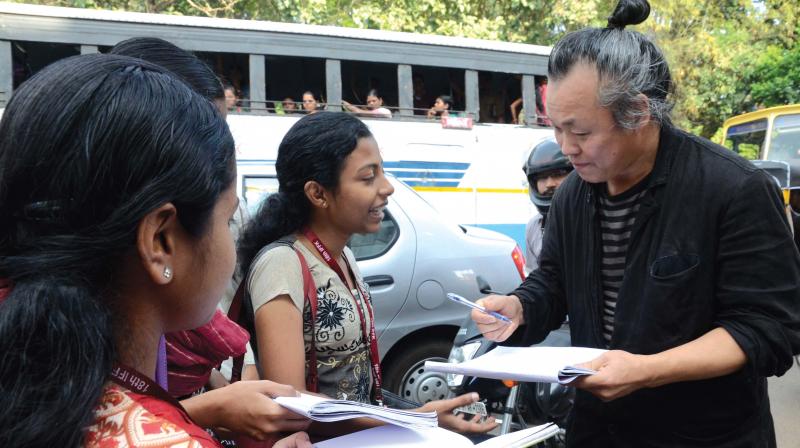 South Korean director Kim Ki Duk signs autograph during his visit to Thiruvananthapuram in 2013. 	 DC File