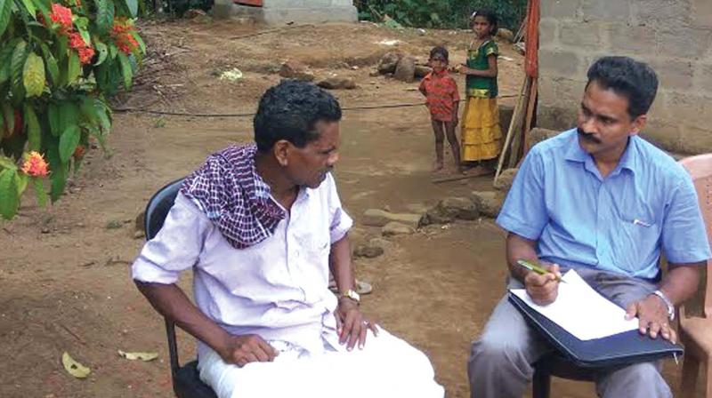 An official of the economics and statistics department of the state government collecting details of tribals of Variyam colony from the tribal head. (Photo: DC)