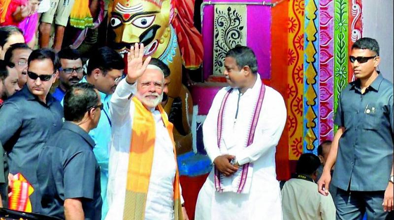 Prime minister Narendra Modi waves at people during his visit to Lord Lingaraj temple in Bhubaneswar on Sunday. (Photo: PTI)