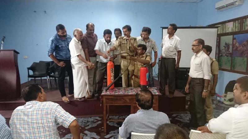 District fire officer Arun Baskher briefs about the functioning of a fire extinguisher to the community volunteer team at sports council hall on Friday. (Photo: DC)