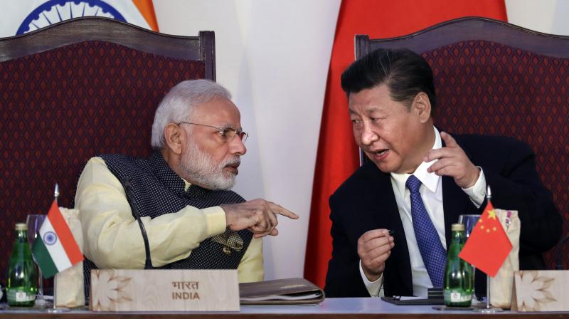 Indian Prime Minister Narendra Modi, left, talks with Chinese President Xi Jinping at the signing ceremony by foreign ministers during the BRICS summit in Goa, India. (Photo: AP)