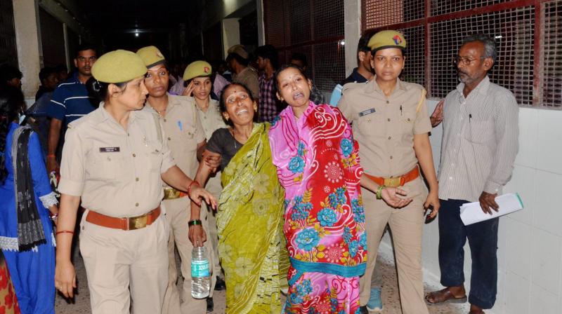 Family members and relatives mourn outside the BRD Hospital in Gorakhpur on Friday where at least 30 children died since the past two days, allegedly due to oxygen supply cut. (Photo: PTI)