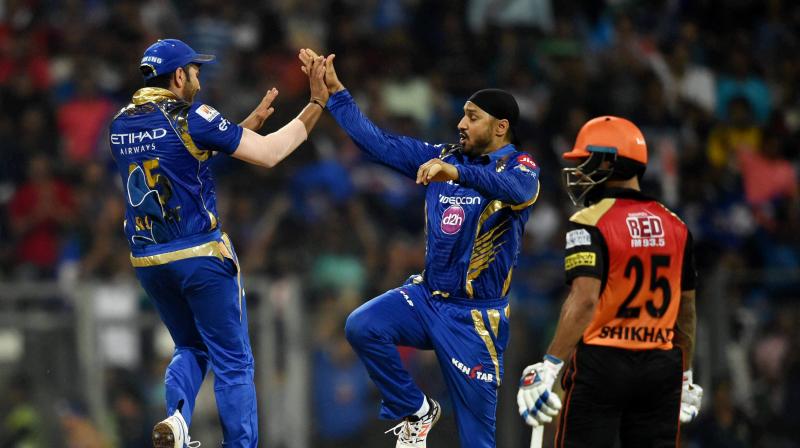 Harbhajan Singh celebrates with a teammate the dismissal of Sunrisers Hyderabads David Warner during their IPL match. (Photo: PTI)