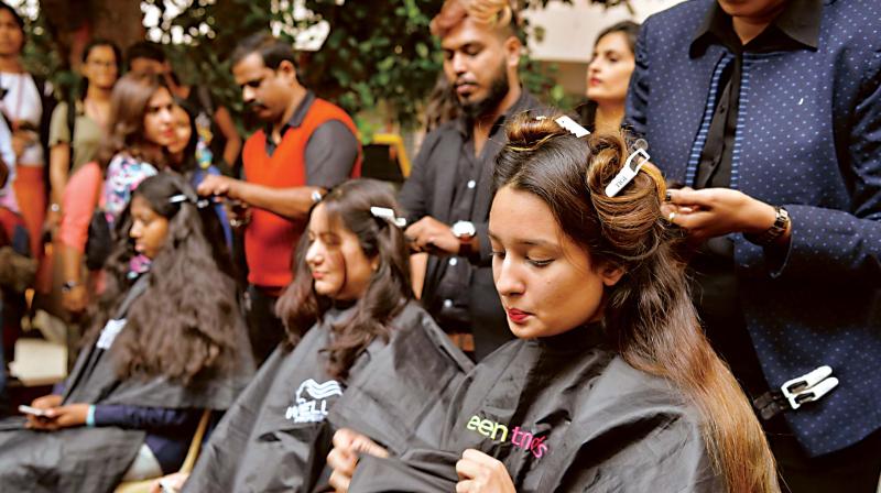 Girls getting a haircut as part of the Gift hair gift confidence programme at Mount Carmel College, in Bengaluru on Wednesday. (Image Dc)