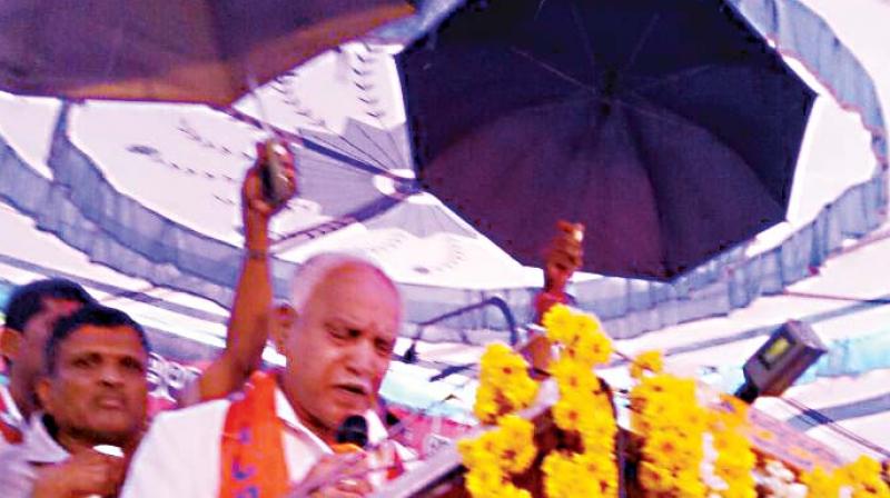 State BJP chief Yeddyurappa addresses a gathering even as rain lashed Hassan on Monday (Photo: DC0