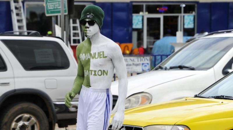 A man stands in the sweltering heat for hours, painted head to toe in the colours of a fashion house, at a traffic junctions in the Liberian capital of Monrovia on May 25, 2017. (Photo: AFP)