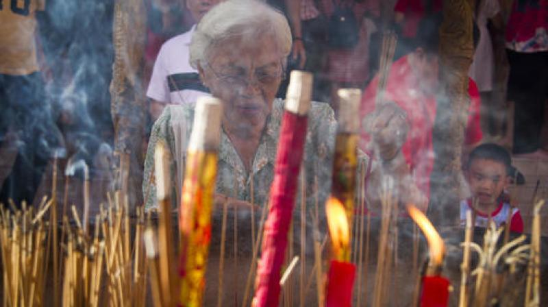 Wearing heavy winter coats, they lit incense sticks and bowed as they prayed for good fortune and health. (Photo: AP)