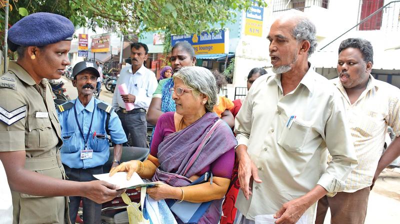 A woman cop helping senior citizens at a bank in Villivakkam. On Saturday, banks were operational for senior citizens to deposit and exchange invalid currencies of Rs 500 and Rs 1,000 (Photo: DC)