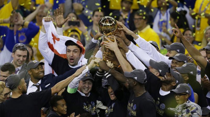 Golden State Warriors players, coaches and owners hold up the Larry OBrien NBA Championship Trophy after Game 5 of basketballs NBA Finals (Photo: AP)