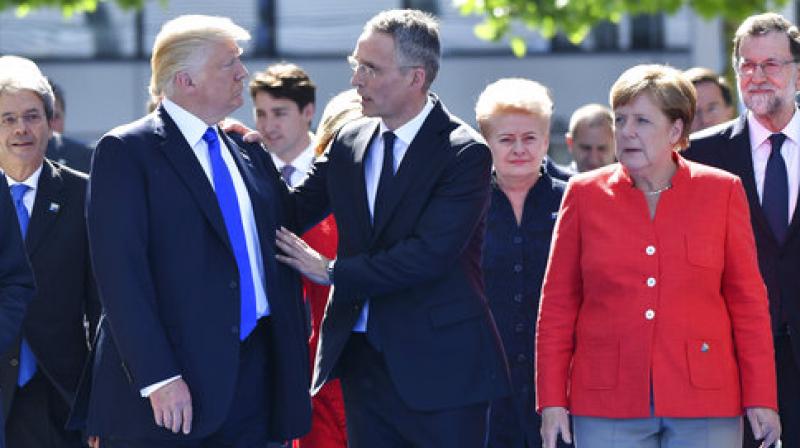 US President Donald Trump, left, NATO Secretary General Jens Stoltenberg and German Chancellor Angela Merkel walk through NATO headquarters at the NATO summit in Brussels. (Photo: AP)