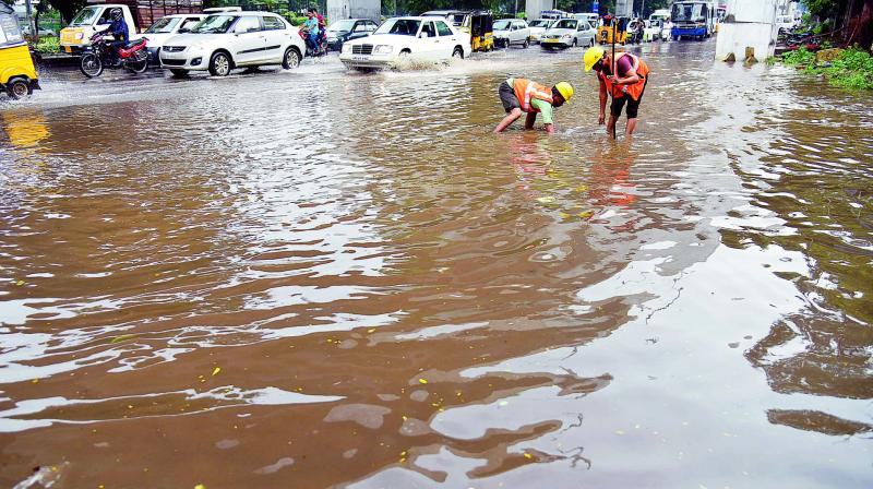 GHMC workers clear water logged near the Police control room, due to the heavy rains on Wednesday. (Photo: DC)