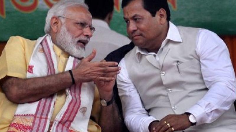 Prime Minister Narendra Modi and Assam Chief Minister Sarbananda Sonowal sharing a moment during the celebration of th anniversary of NDA government at the Centre, and first anniversary in the state, at veterinary college field in Guwahati on Friday. PTI Photo