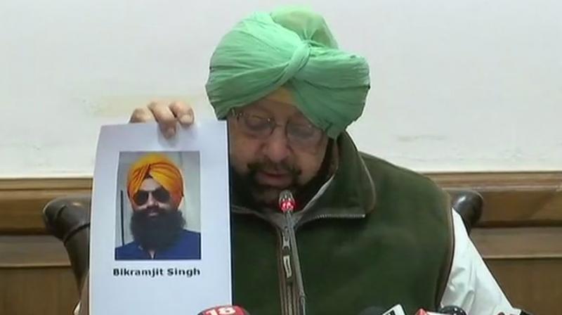 CM Amarinder Singh holds up photo of 26-year-old Bikramjit Singh who has been arrested. (Photo: ANI/Twitter)