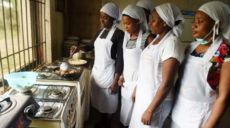 Women learn to cook at Idia Renaissance non-governmental organisation in midwest Nigeria. (Photo: AFP)