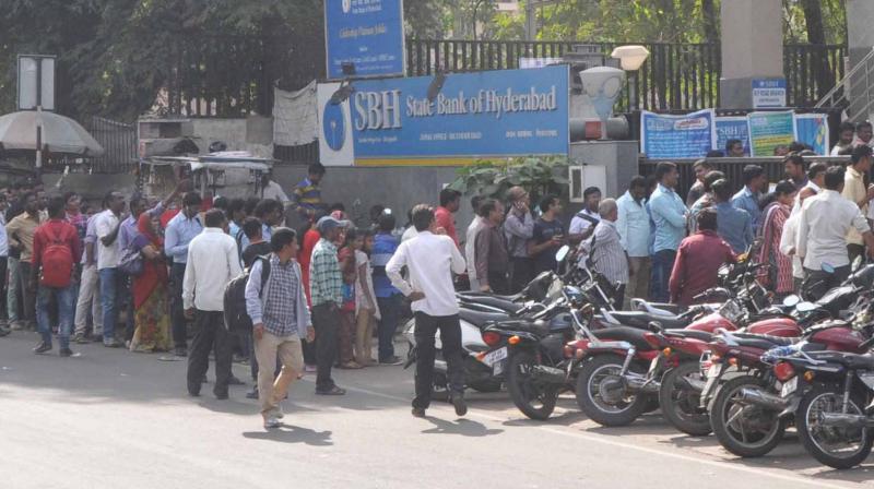 People queue up at an SBH ATM in the city for withdrawing cash on Saturday.