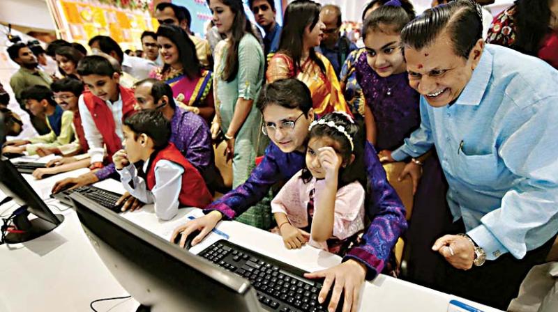 Stockbrokers trades as their family watch during a special muhurat trading session for Diwali at BSE in Mumbai, on Wednesday.