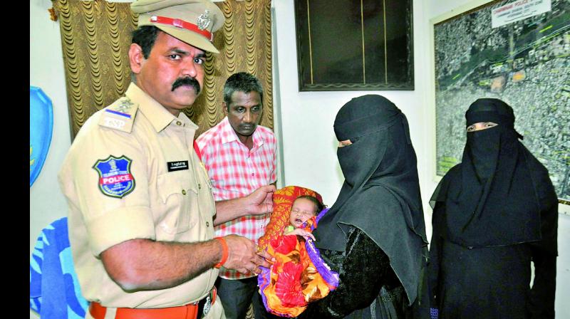 Tameena with the baby at the Charminar police station on Friday. 	(Photo: DC)