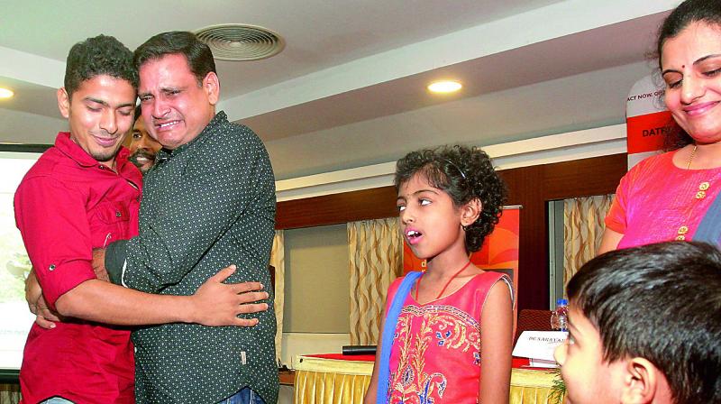 Kiran Kumar, father of Thalassemia survivor Manasvi Karamchedu, weeps as he embraces T.S. Shabas who had donated stem cells to Manasvi, in Kochi on Thursday