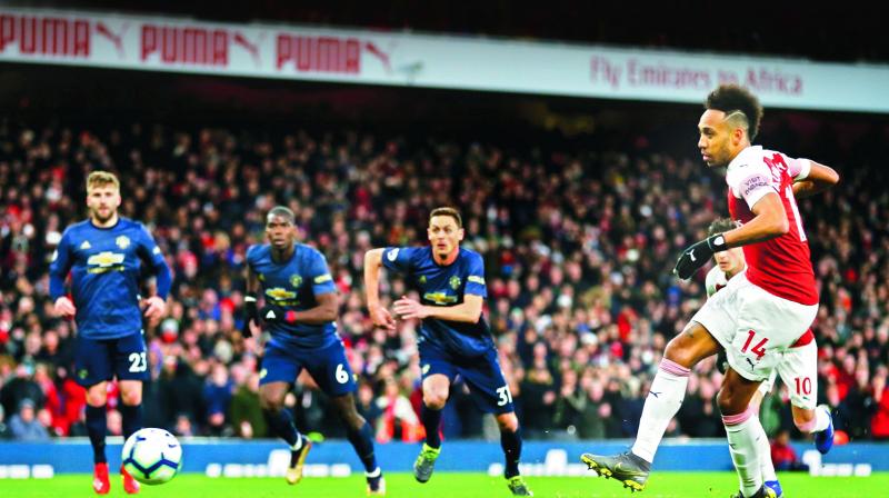 Arsenals Pierre-Emerick Aubameyang (right) scores against Manchester United in their EPL match at the Emirates Stadium in London on Sunday. (Photo: AFP)