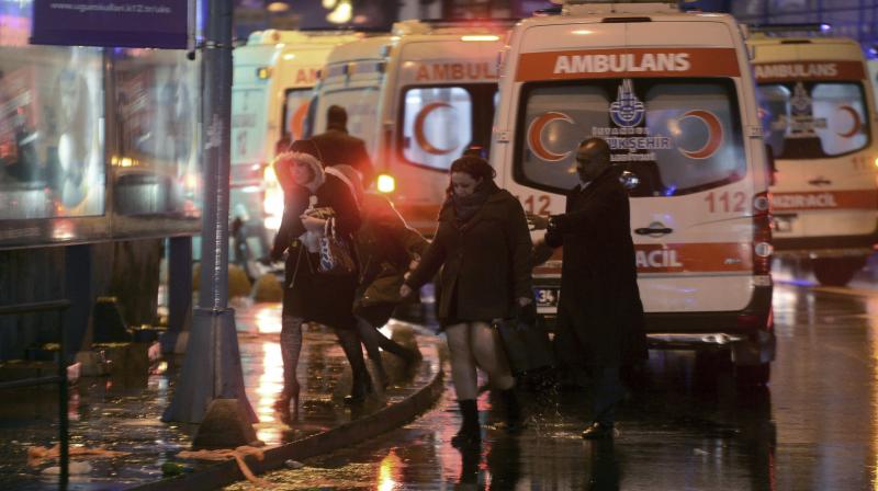 People leave as medics and security officials work at the scene after an attack at a popular nightclub in Istanbul. (Photo: AP)