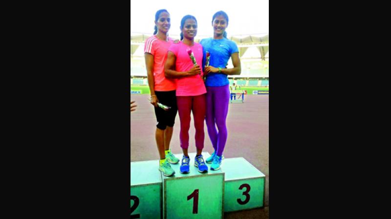 Sprinter Dutee Chand (centre) is all smiles as she poses with second placed Merline Joseph and bronze medallist Himanshi Roy at the Indian Grand Prix at the Jawaharlal Nehru Stadium in New Delhi on Monday.