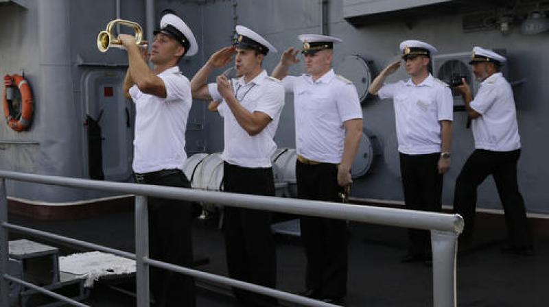 Members of the Russian Navy salute on board the Russian vessel Admiral Tributs, a large anti-submarine ship, as it docks at Manilas pier, Philippines. (Photo: AP)