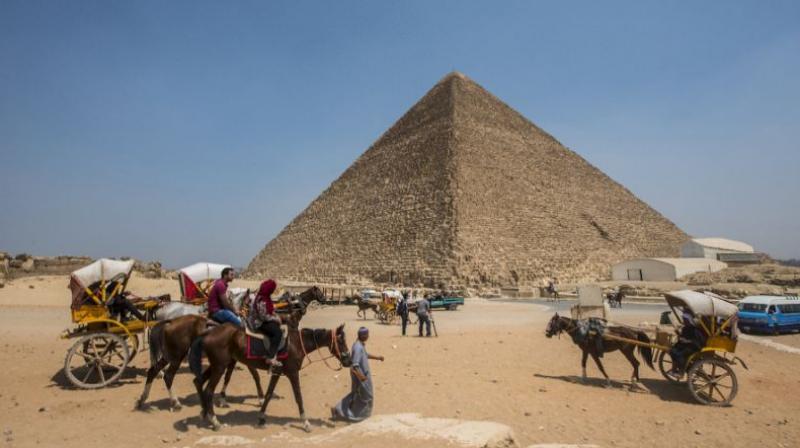 Egyptians ride their carts past the Great Pyramid of Cheops, aka Pyramid of Khufu on the Giza Plateau. (Photo: AFP)