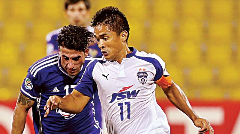 Bengaluru FCs Sunil Chhetri vies for the ball with Ahmed Kadhim of Air Force Club during their match in Doha (Photo: AFP)