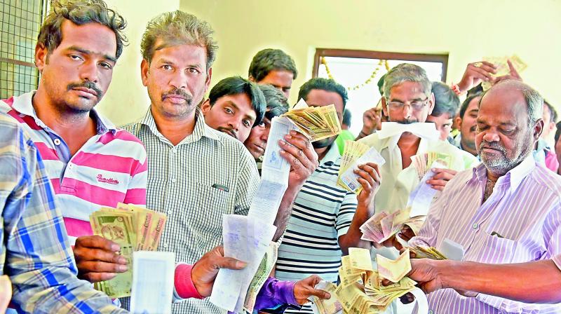 People in queue shows their electricity bills with Rs 500 and Rs 1,000 old notes at Jubilee Hills on Friday. (Photo: Deccan Chronicle)